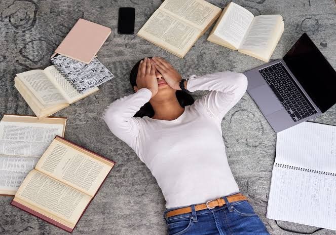 Female student surrounded by open books, reflecting on her NEET to BDS journey